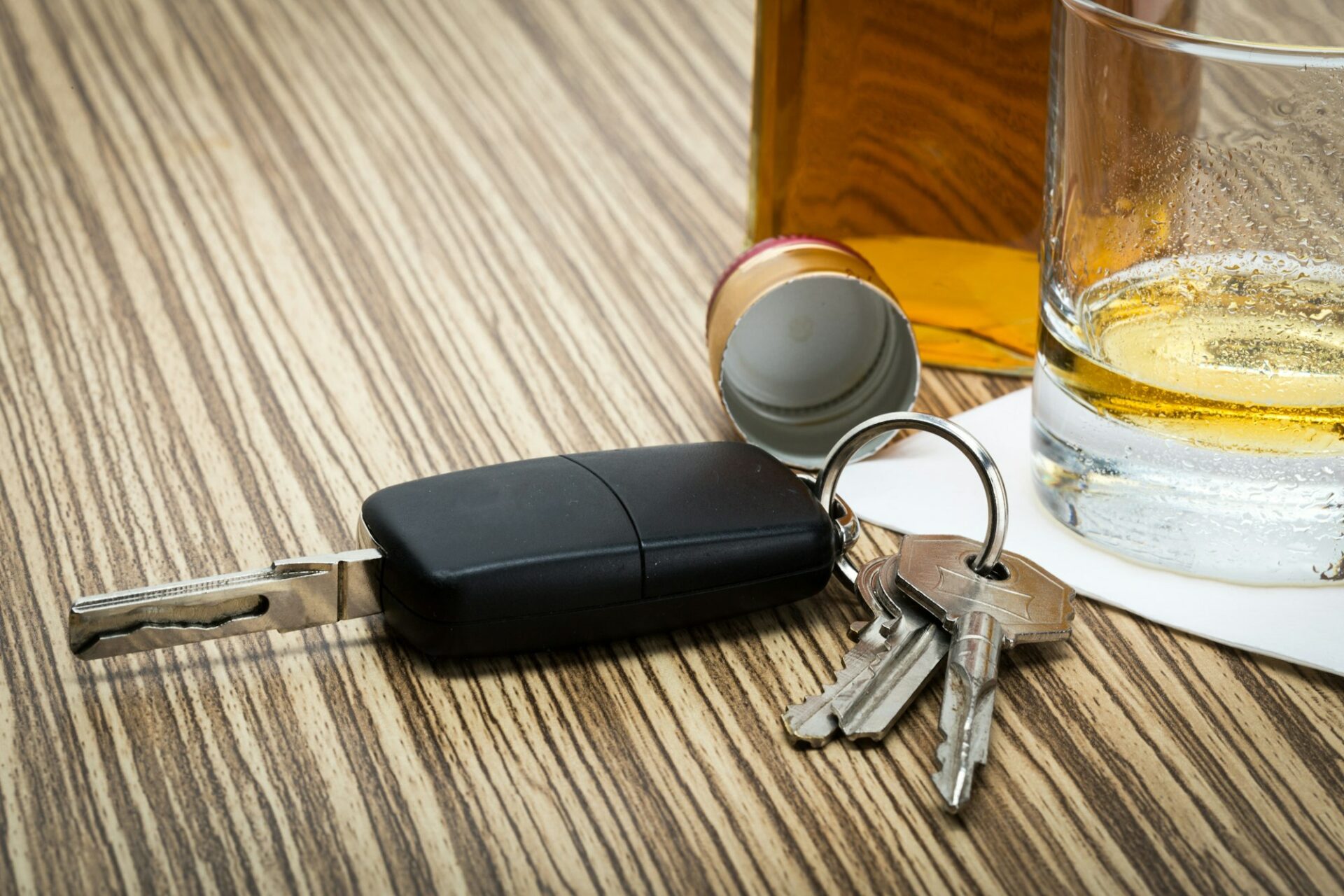 Car key on the bar with spilled alcohol