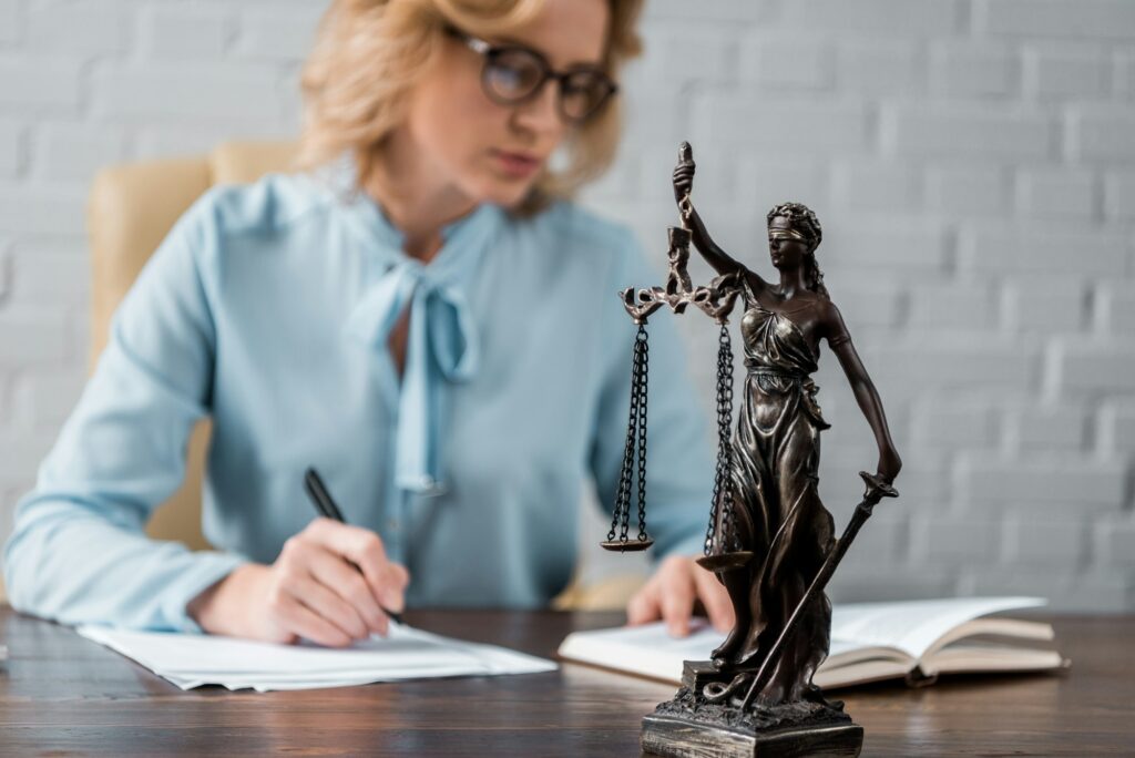 close-up view of lady justice statue and female judge working behind