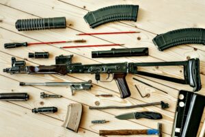 Disassembled rifle with cleaning tools on table of weapons workshop