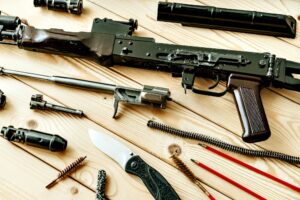 Disassembled rifle with cleaning tools on table of weapons workshop