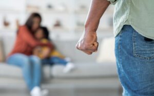 Domestic Violence. African American Man Threatening Wife And Daughter With His Fist