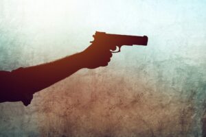 Hand with a gun on grunge background