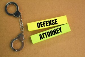 iron handcuffs and colored paper with the word defense attorney.