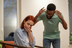 Mad angry African American man husband blaming and shaming wife at home. Domestic violence concept