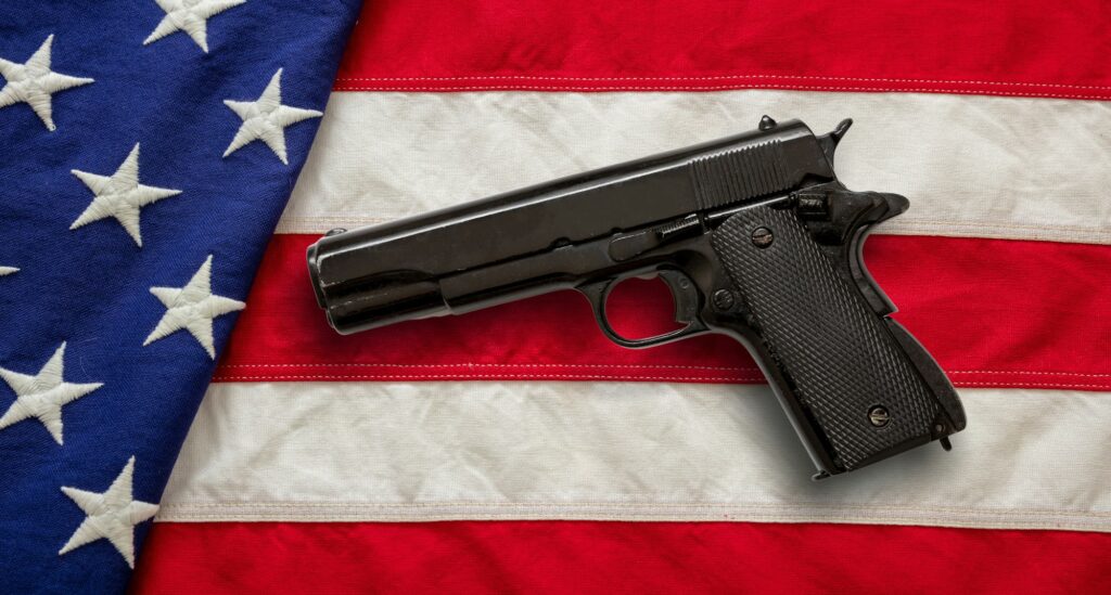Pistol on US America flag background, top view. Gun laws in United states, self defence concept