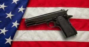 Pistol on US America flag background, top view. Gun laws in United states, self defence concept