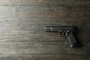 Pistol on wooden background. Self defense weapon