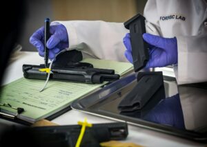 Police scientist notes serial number on sealed firearm in crime lab, conceptual image