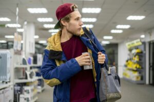 shoplifter in the electronic store supermarket stealing new gadget f