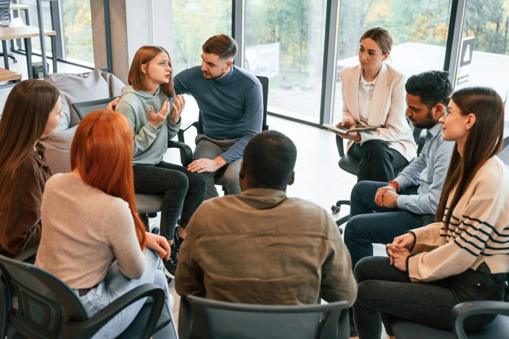 Supporting the woman. Group of people are having therapy meeting together