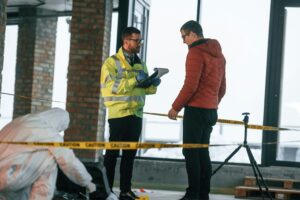 The witness is being questioned. Two detectives are collecting evidence in a crime scene