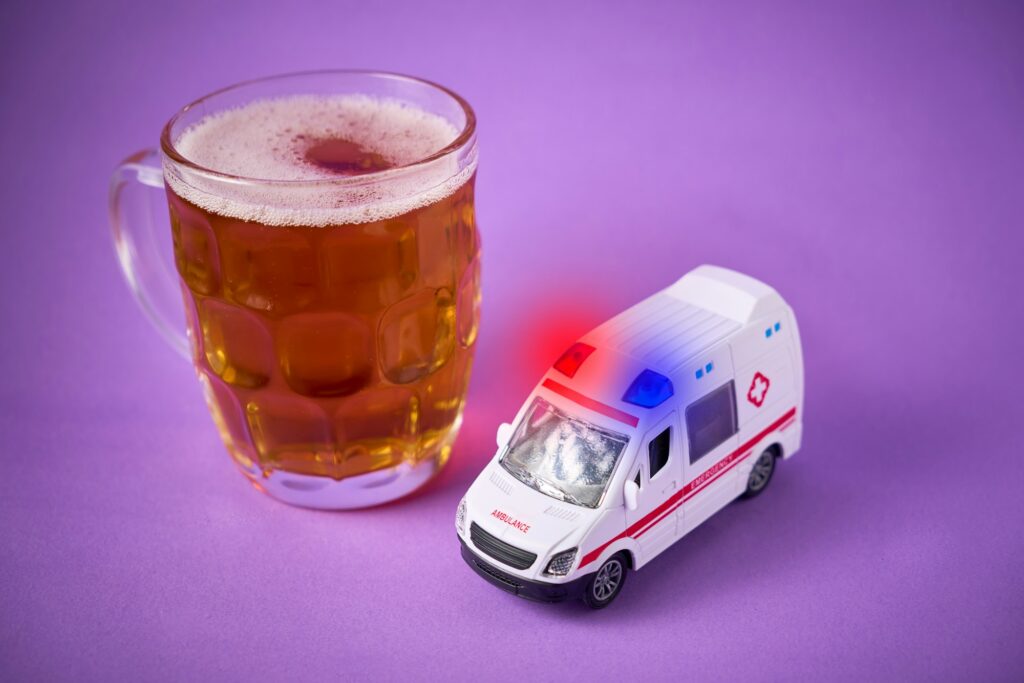 Toy ambulance with a jar of beer. Drunk driving concept and breathalyzer