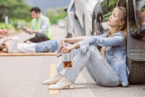 women teen drunk drink alcohol during drive a car accident at roadside sitting sleep unconscious