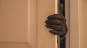 Gloved hand opening the door, Housebreaking, burglary concept