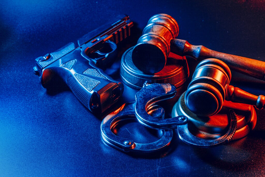 Gun and judge's gavel on the table. Crime, robbery, attack concept