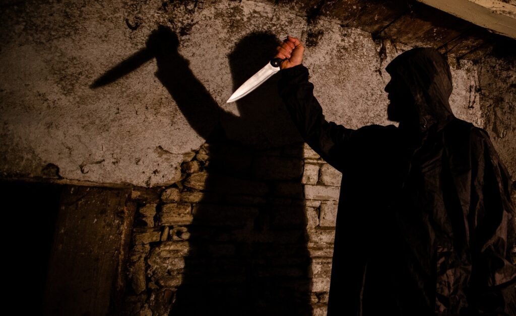 murderer with big knife and shadow horror scene