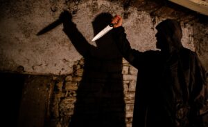 murderer with big knife and shadow horror scene