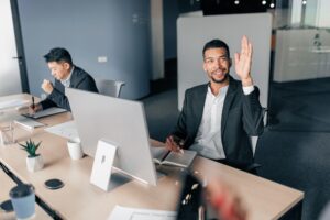 Young worker raise his hand up to ask a question to business team leader