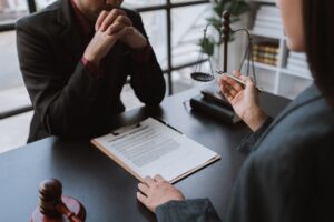 Young businessman concentrating on signing a contract with a skilled female lawyer and financial adv