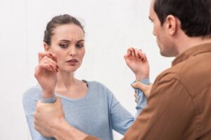 angry man holding hands of woman during argument