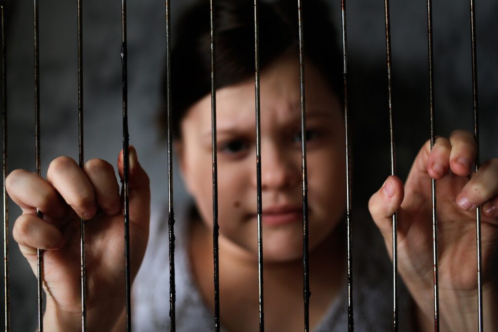 child in cage, concept of restriction of freedom