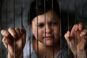 child in cage, concept of restriction of freedom
