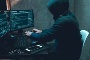 Hacker programmer using computer in dark room