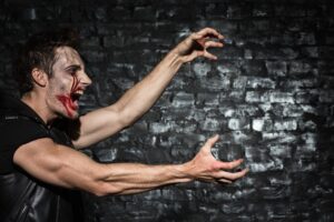 Strong zombie man stretching clawing creepy hands, while attacking someone
