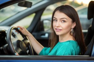 Successful woman drives a car. The concept of transportation, right to drive and insurance.