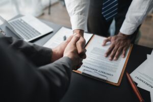 Two lawyers shake hands in a brainstorming meeting. Lawyers search for legal information together to