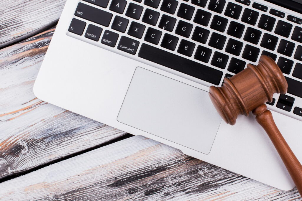 Wooden court gavel on a laptop keyboard.