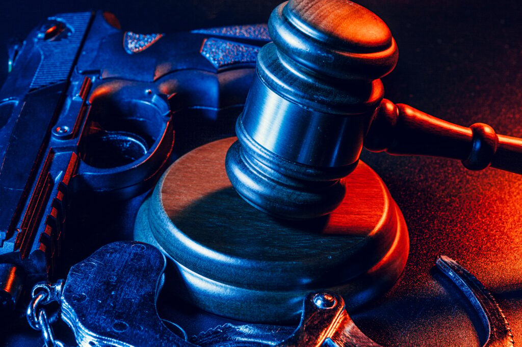 Gun and judge's gavel on the table. Crime, robbery, attack concept