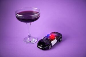 Toy police car with a wine glass. Drunk driving concept and breathalyzer
