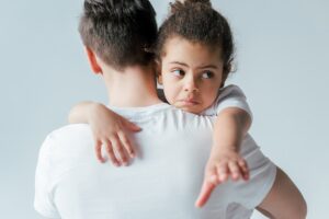 back view of foster father taking away sad african american daughter isolated on white, custody