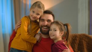 Caucasian happy family bonding affectionate father daughters kids dad parent cuddling little girls
