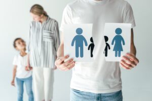 man holding ripped paper with drawn family near woman and adopted african american kid on white