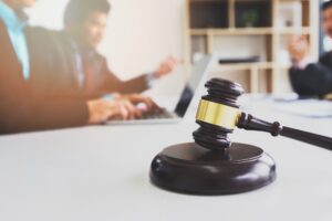 Wooden gavel on table in lawyer's office. Lawyer having team meeting with the client.