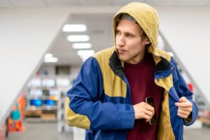 criminal thief stealing cell phone in the shop looking sideways f