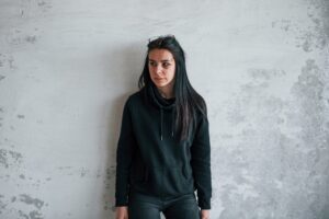 Portrait of beaten young woman with bruise under eye indoors in abandoned building