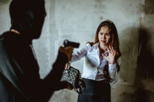 Robber with a gun robbing intimidate a woman surrender.Bandit steals from woman. Crime and robbery.