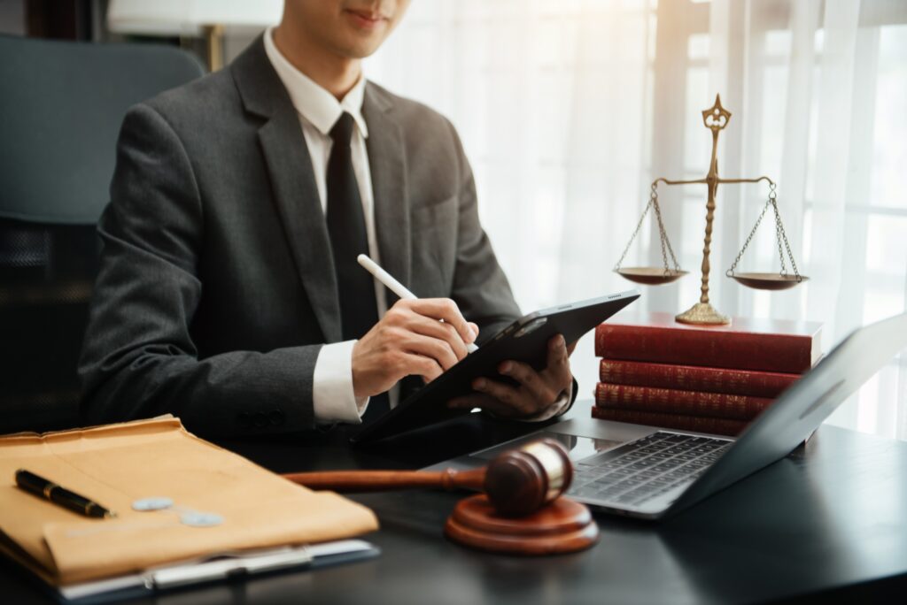 justice and law concept.law theme wooden desk, books, balance. Male judge in a courtroom