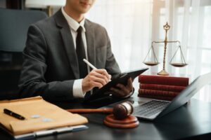 justice and law concept.law theme wooden desk, books, balance. Male judge in a courtroom