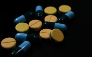 Pill and drug on black background