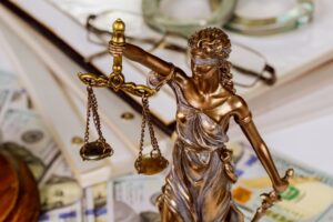 Statue of the lady of justice scales with a file folder with Law documents contracts