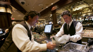 Casino employees handling cash and transaction records that may be reviewed during a Nevada money laundering investigation.