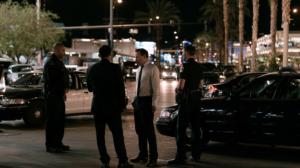 Law enforcement officers discussing an incident during a nighttime investigation in Las Vegas involving alleged public conduct.
