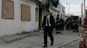 Investigator walking through the scene of a damaged building fire while firefighters examine the property in Nevada.