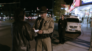 Law enforcement officer speaking with a person during a nighttime investigation related to suspected solicitation in Las Vegas.